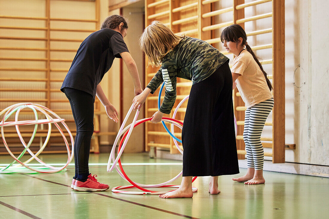 Children playing with hula hoops in school gym