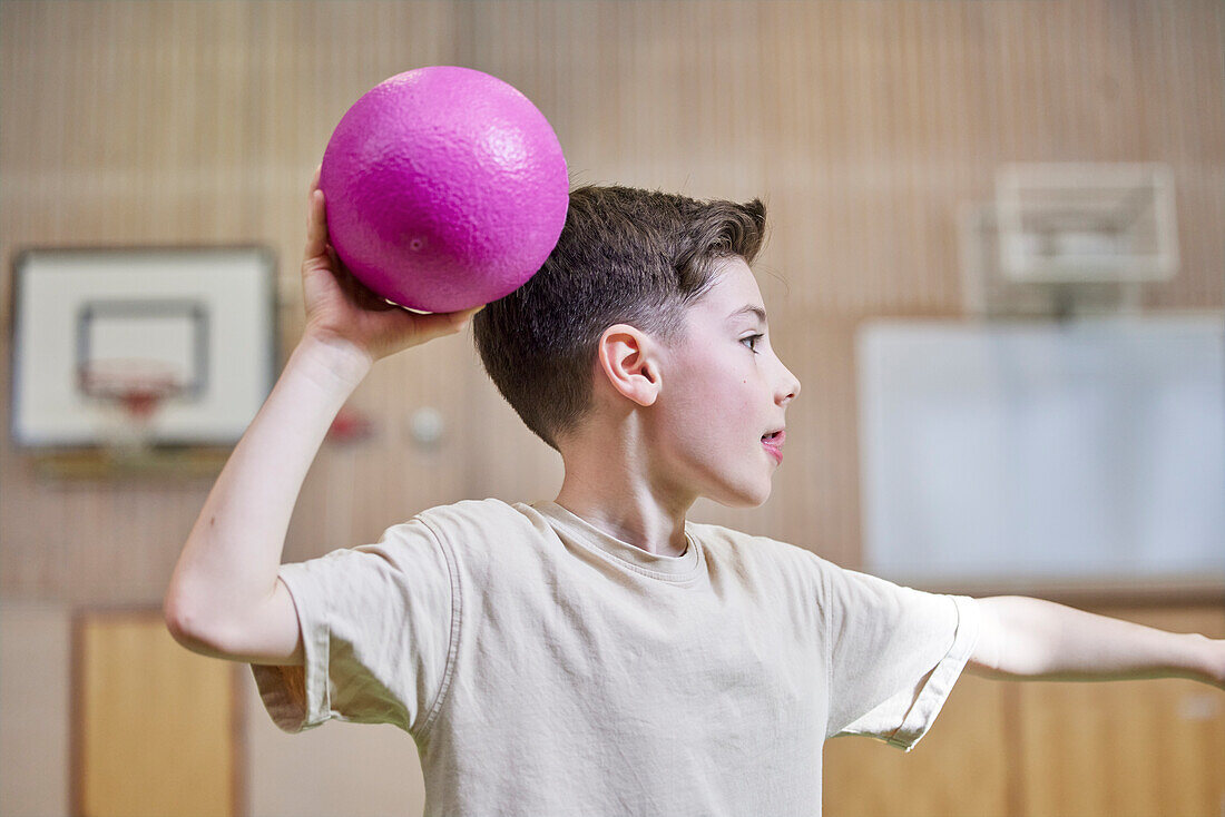 Junge wirft Ball während des Sportunterrichts