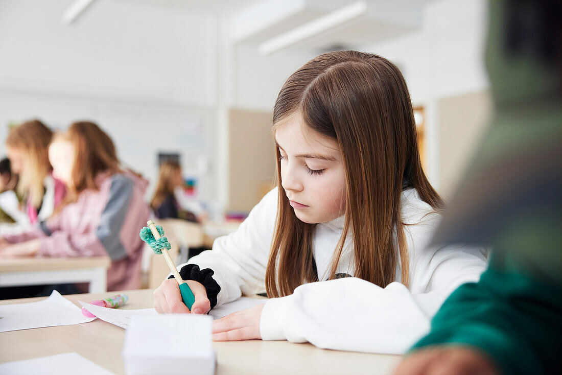 Mädchen, das in der Schule eine Schreibaufgabe erledigt