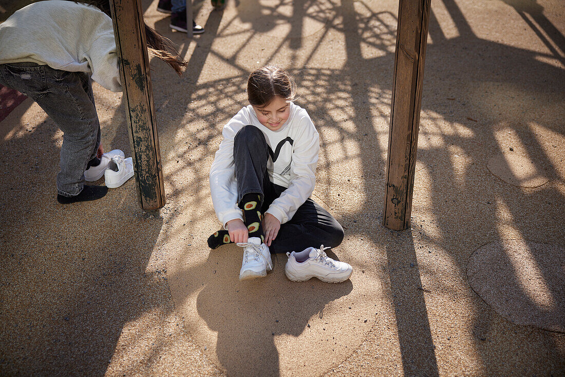 Mädchen sitzt auf einem Spielplatz