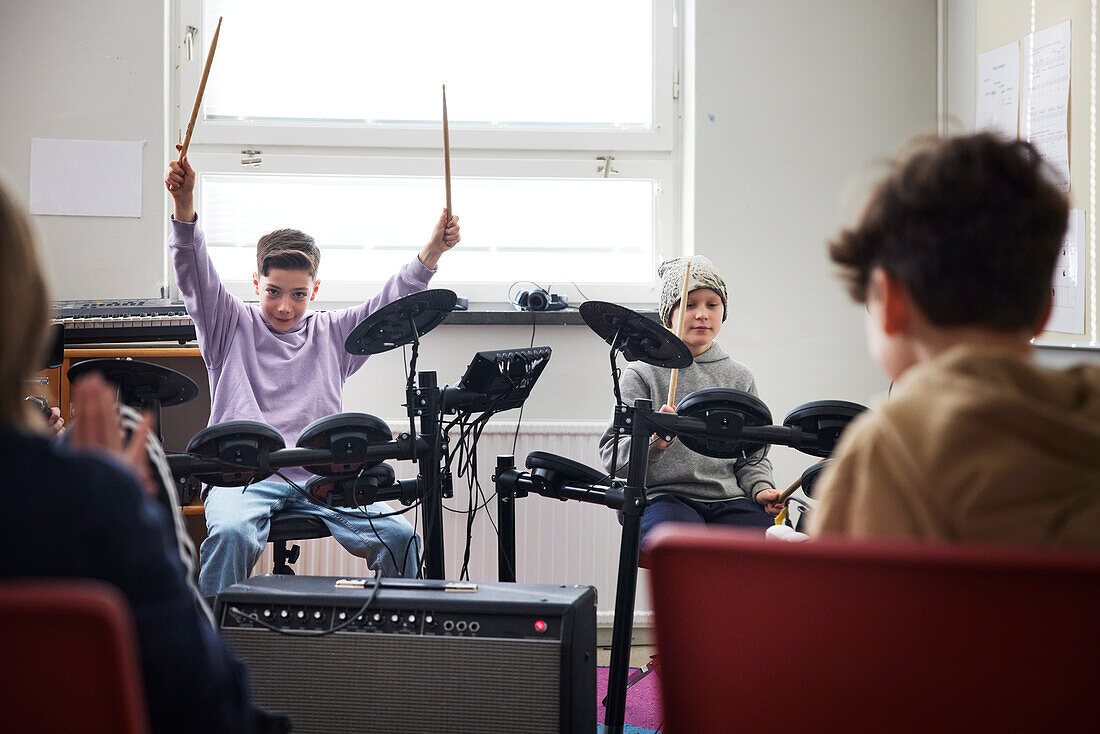 Jungen spielen Schlagzeug in der Schule