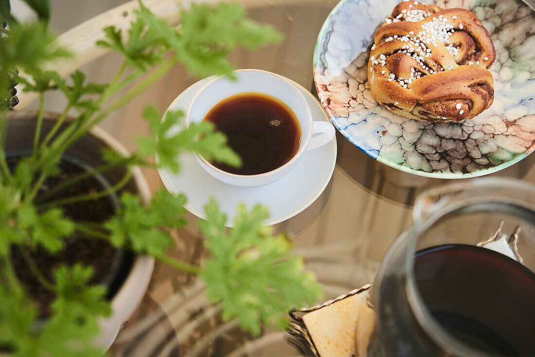 Cup of tea and cinnamon bun on table