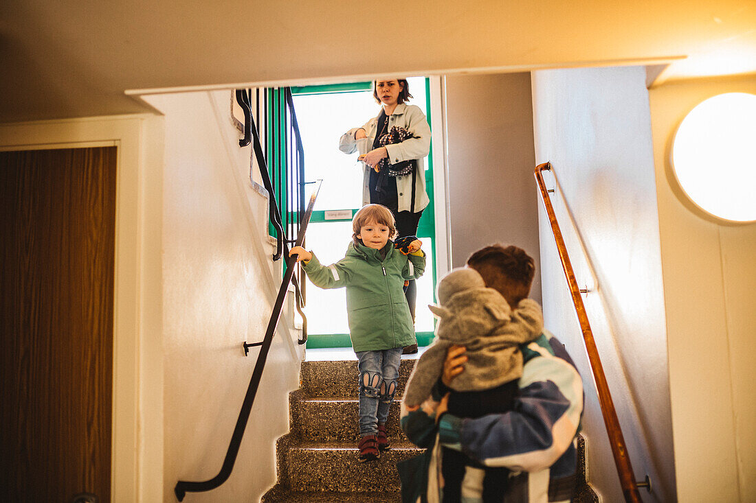 Eltern mit Kindern, die eine Treppe hinuntergehen
