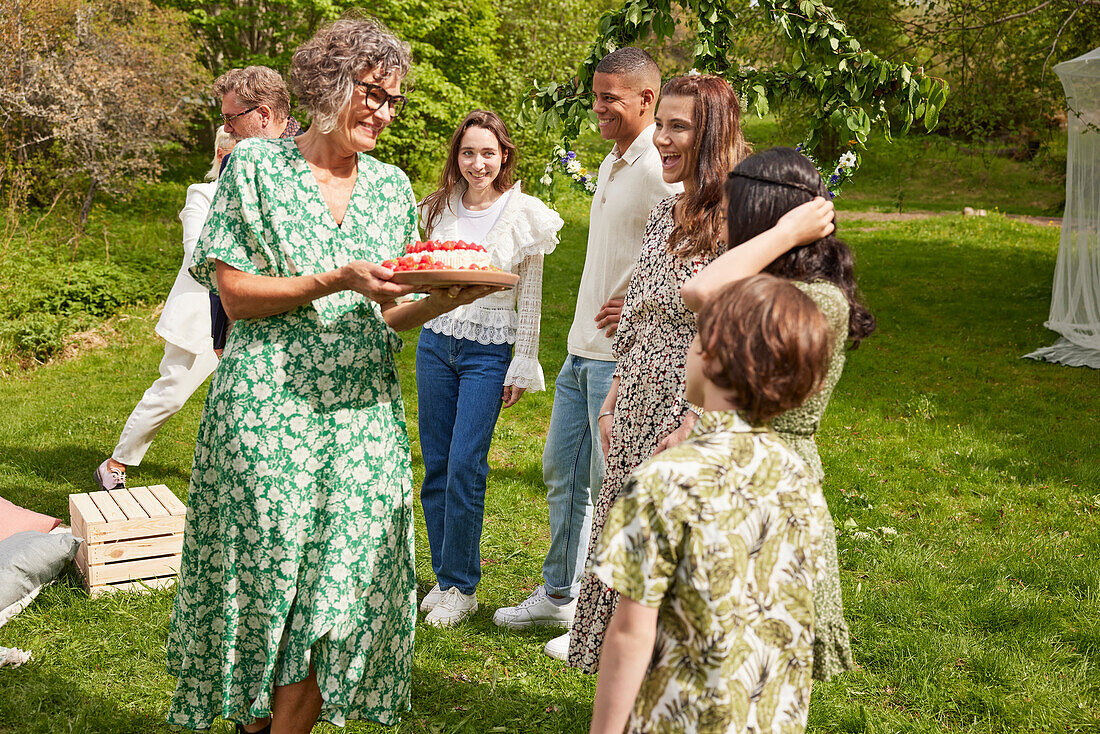 Familie beim Feiern mit Kuchen im Freien