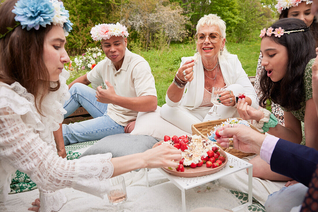 Familie isst Erdbeerkuchen beim Picknick