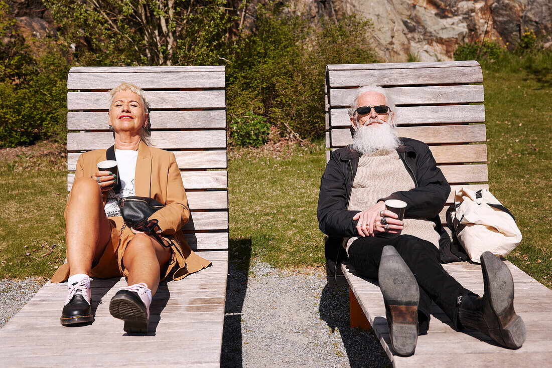 Couple relaxing on sun loungers