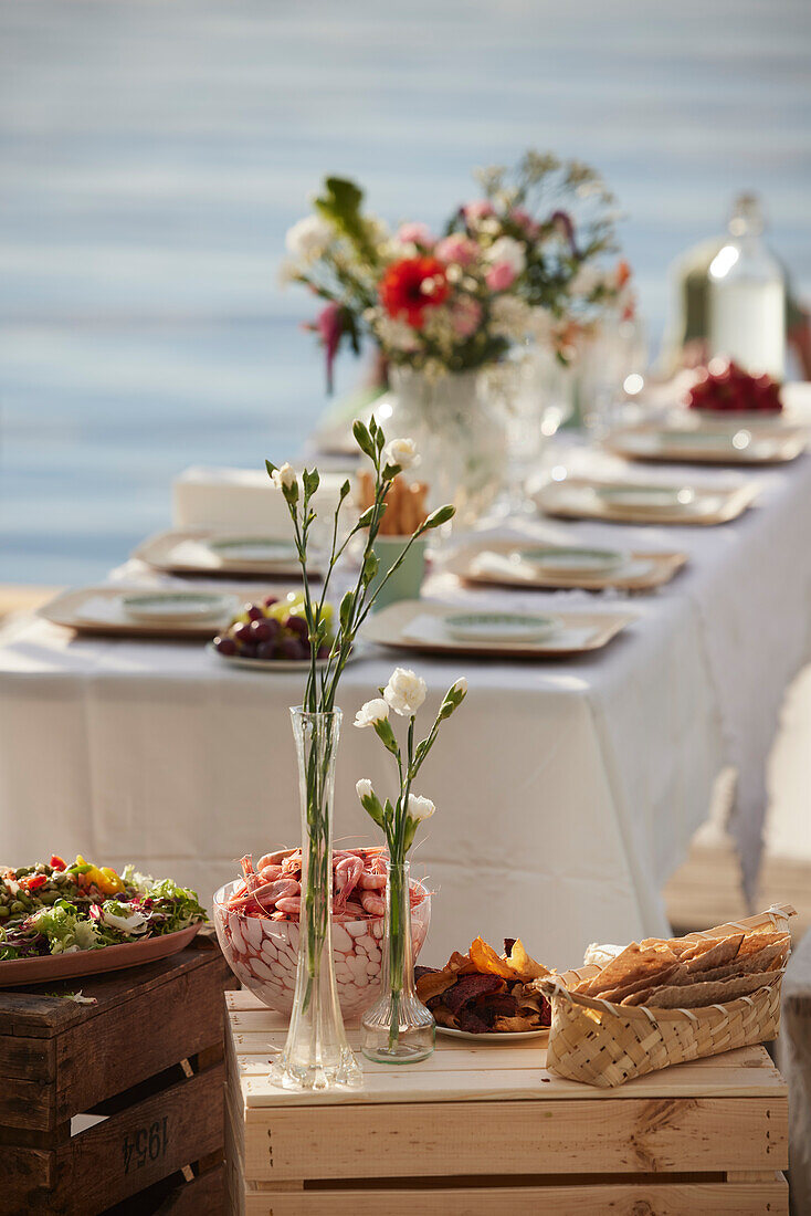 Blumen in Vasen auf Tisch mit Essen