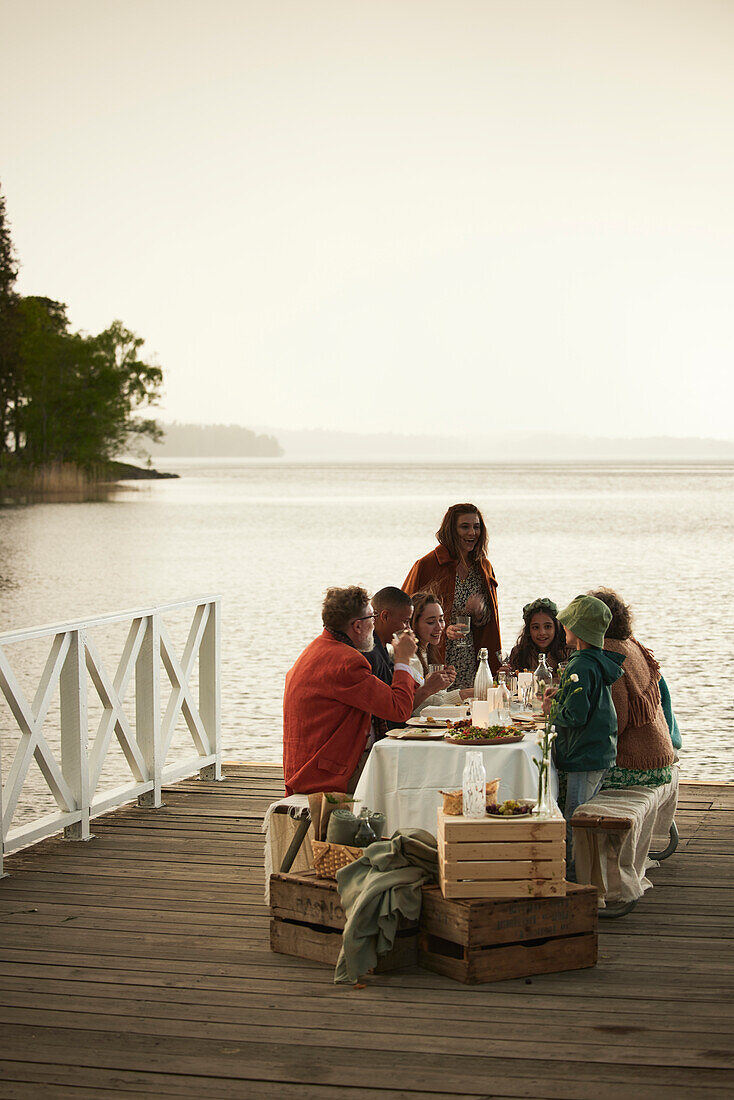 Family having meal at lake