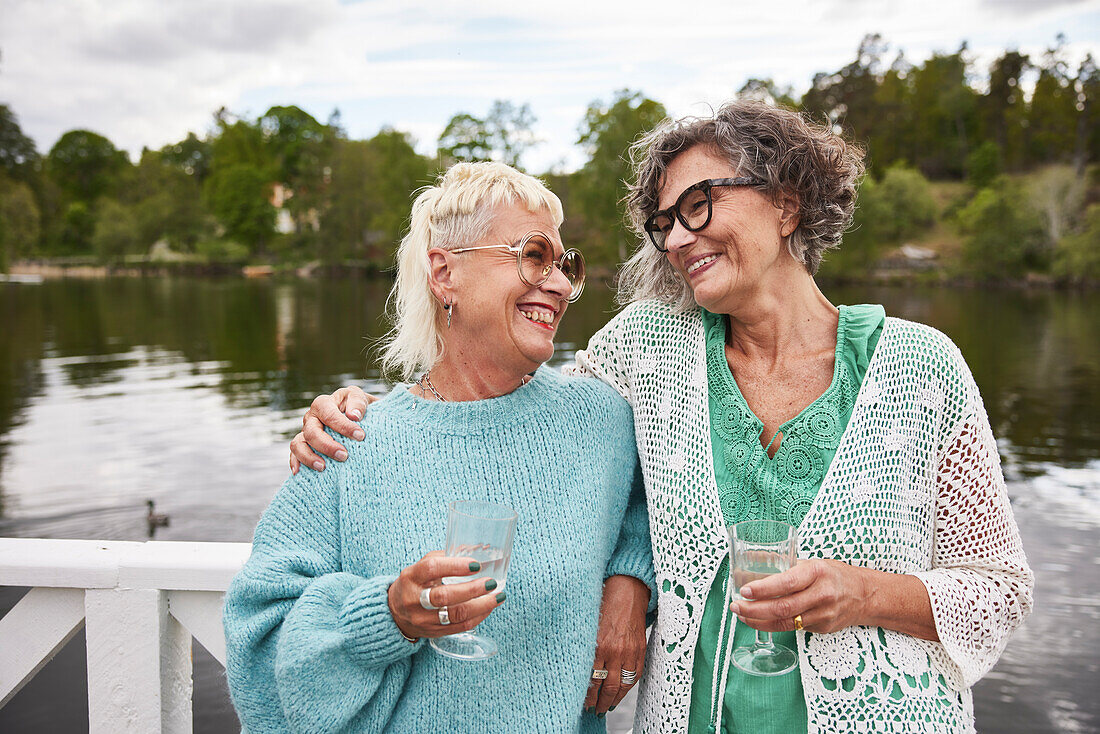 Smiling women standing at lake