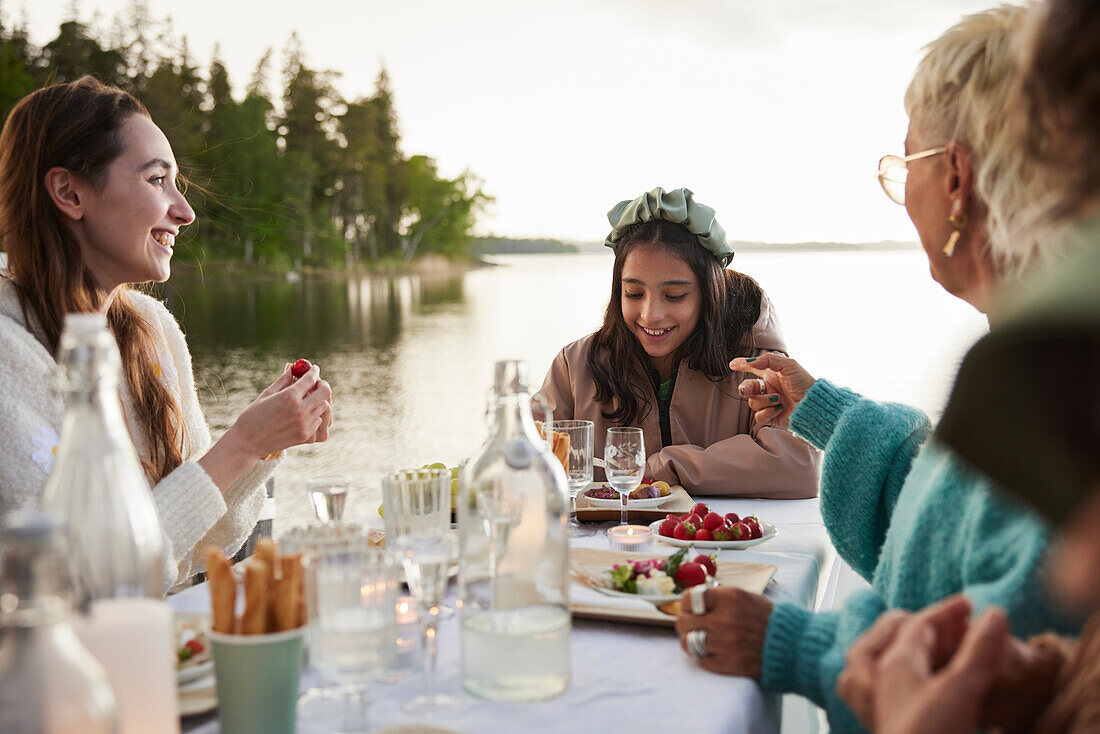 Family having dinner by lake