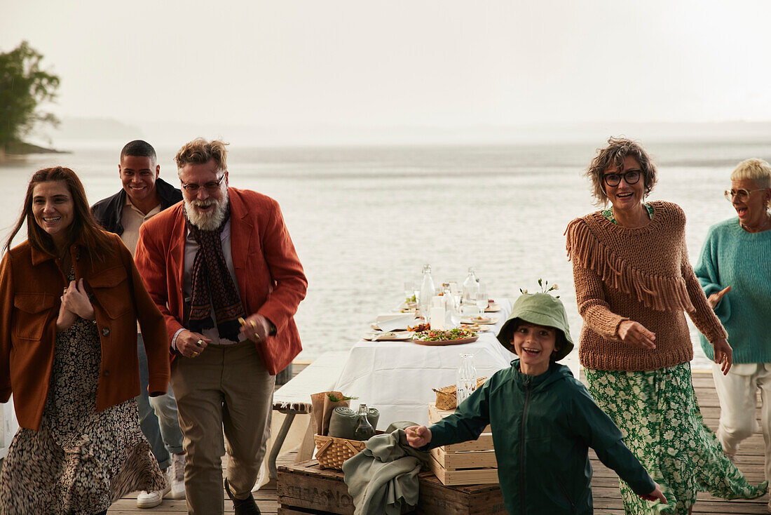 Family leaving dinner table by lake