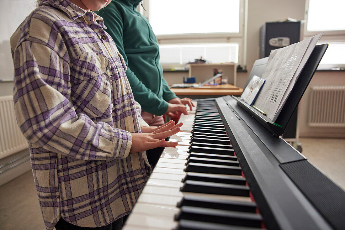 Kinder spielen auf einem Tasteninstrument