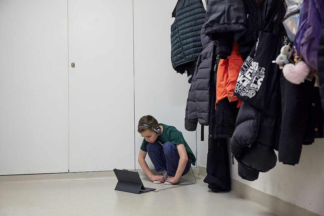 Boy using digital tablet in changing room