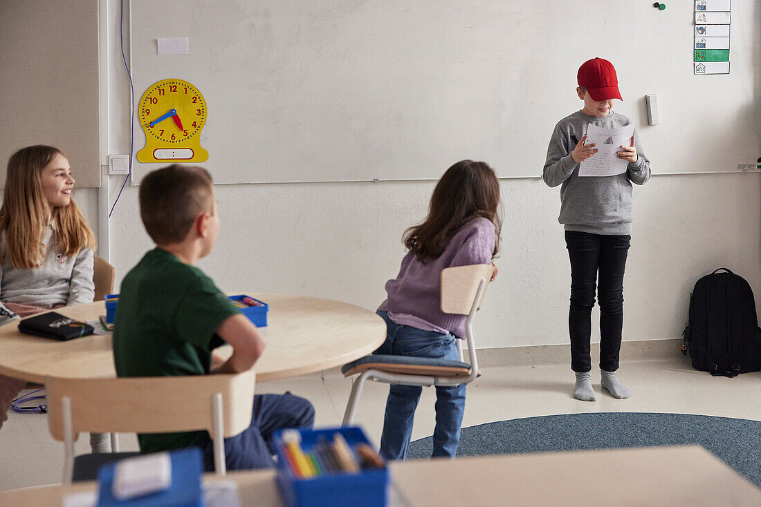 Boy reading in front of class