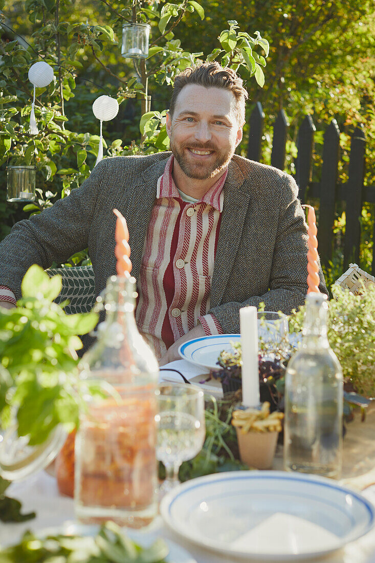 Lächelnder Mann am Tisch im Garten