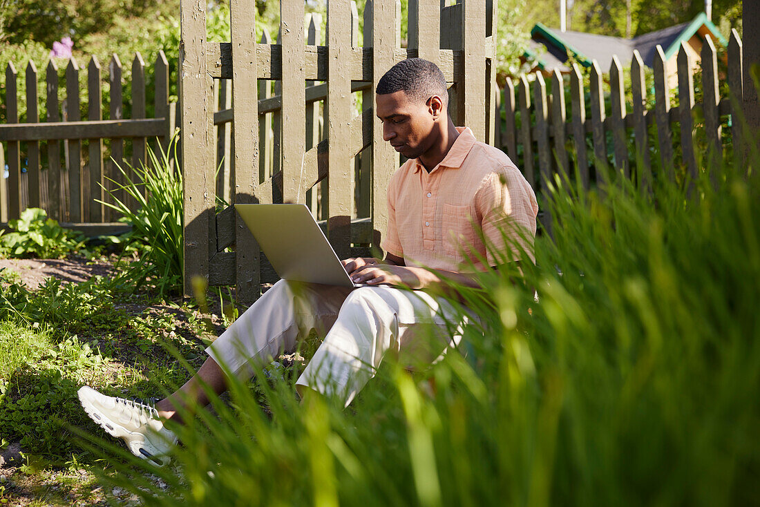 Man with laptop in garden