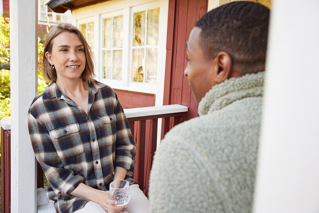 Couple sitting in front of wooden house