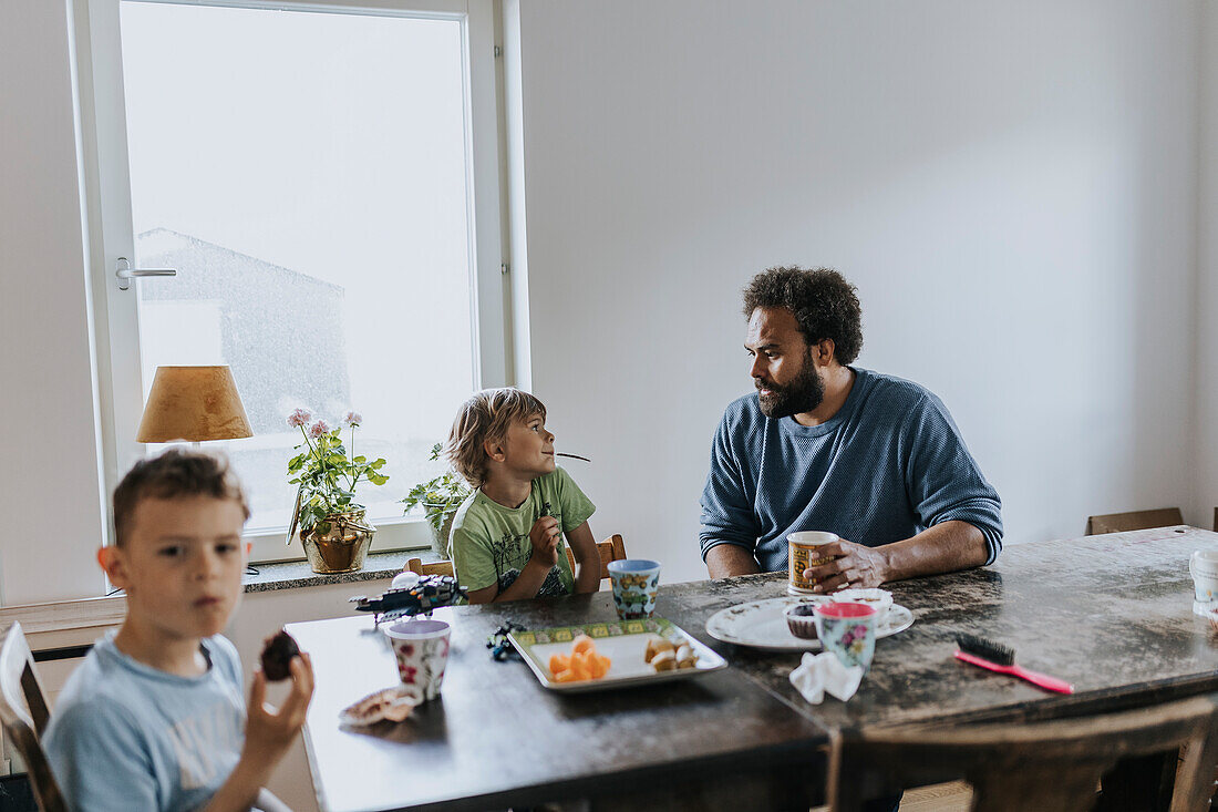 Vater und Kinder essen am Tisch