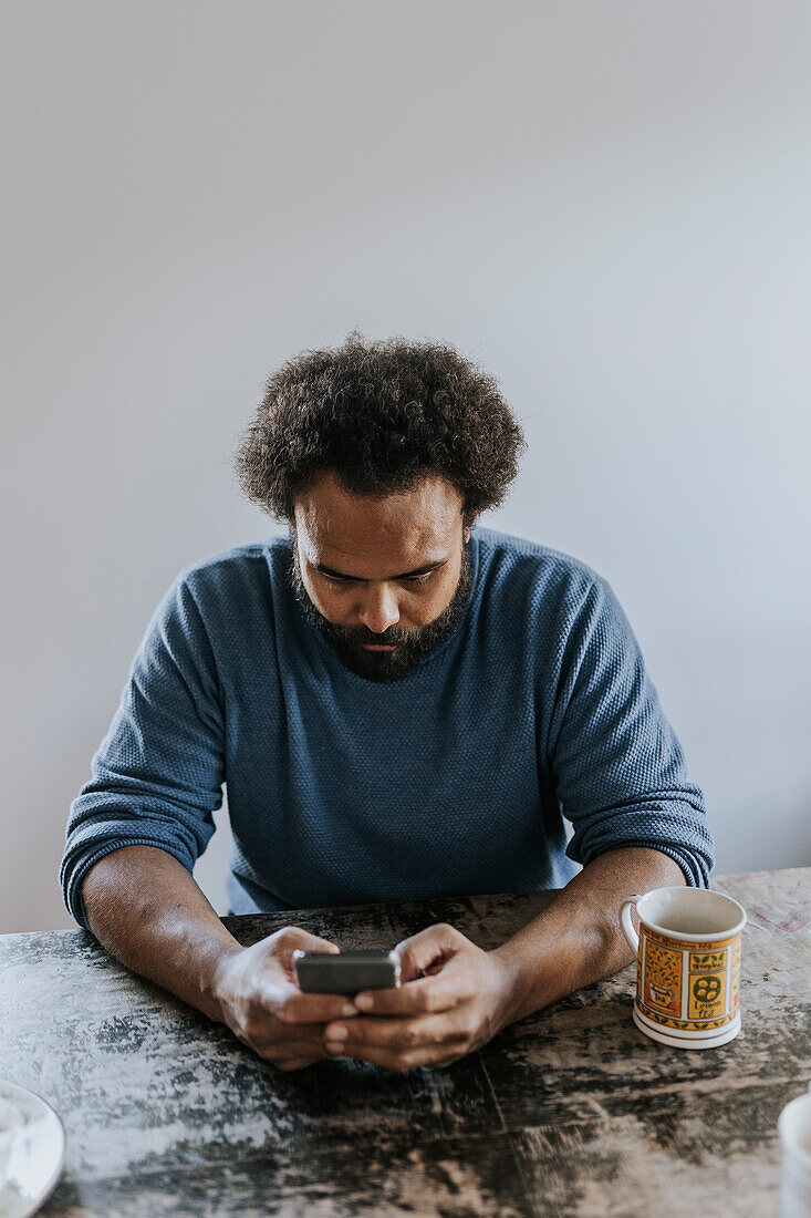 Man sitting at table and using phone