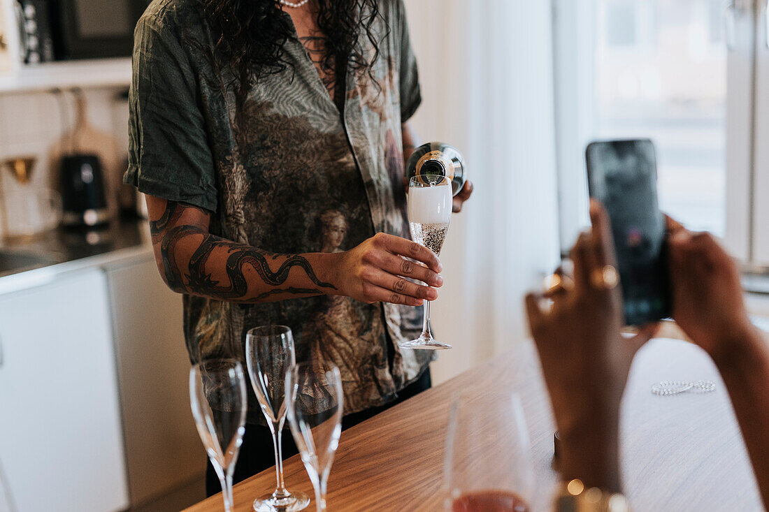 Mid section of man pouring champagne
