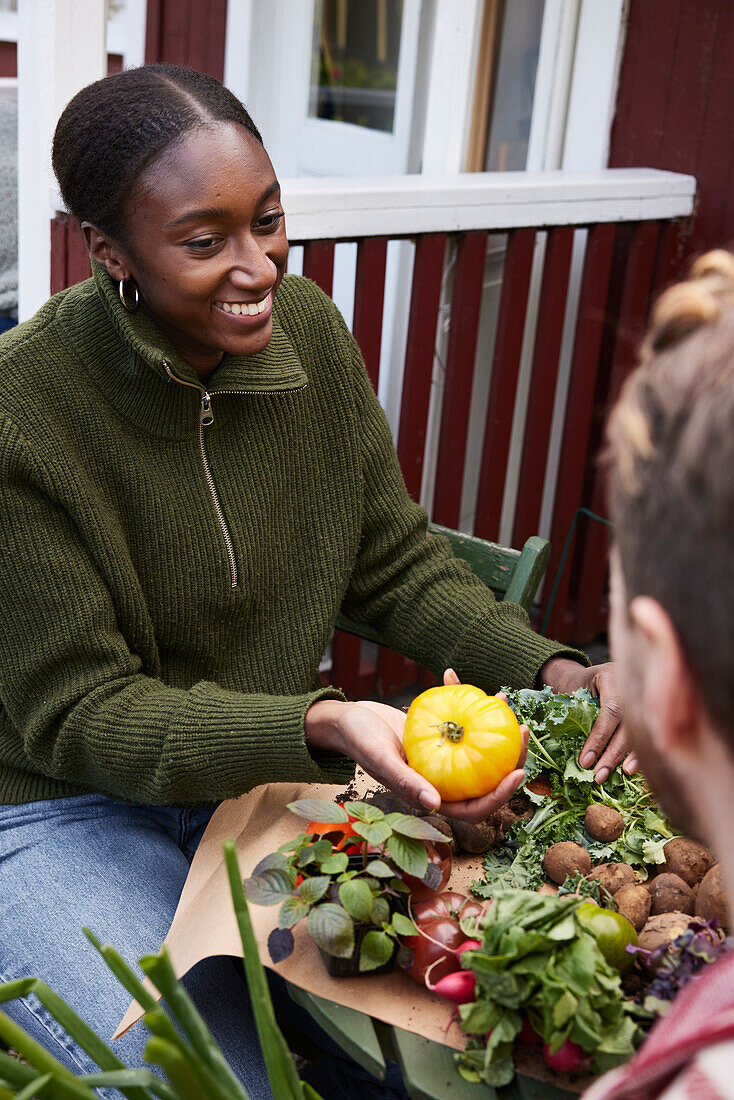 Lächelnde Frau mit Tomate in der Hand