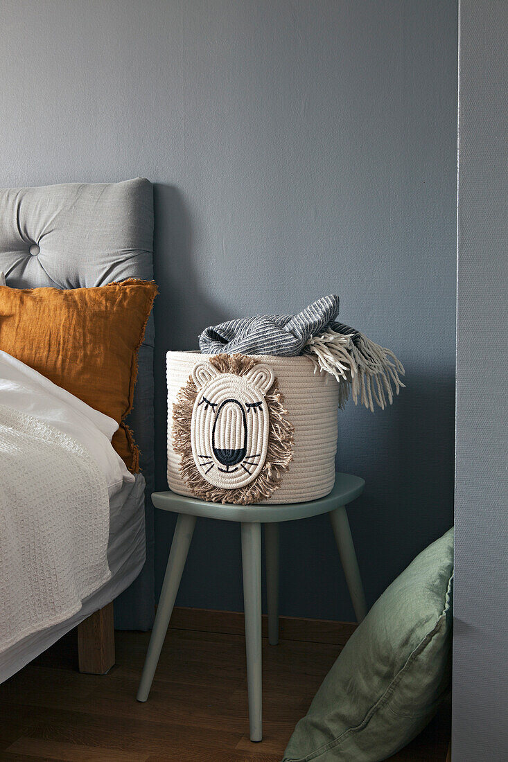 Basket on stool next to bed