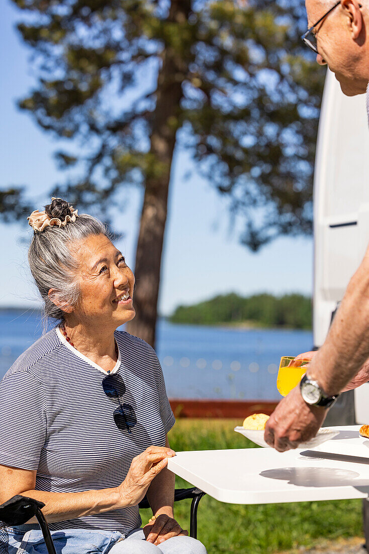 Senior couple having meal at camp site