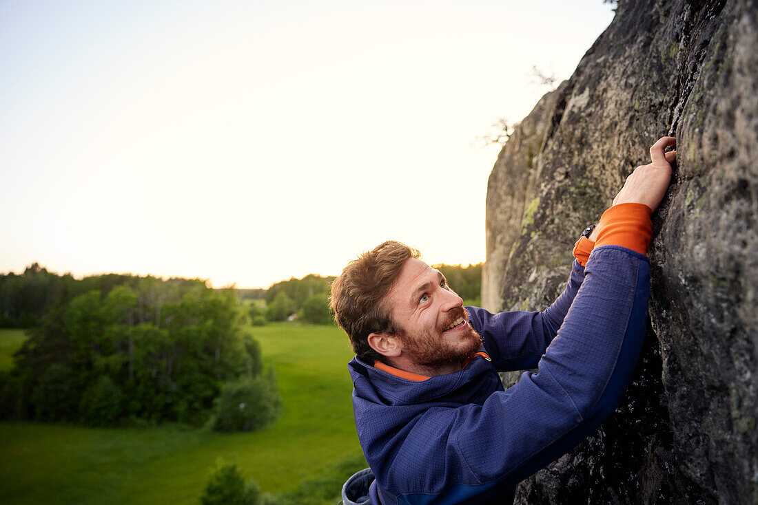 Smiling man rock climbing