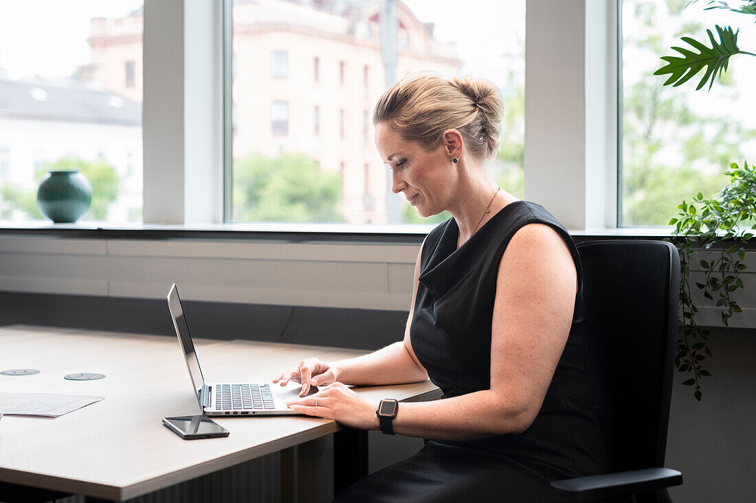 Businesswoman using laptop in office