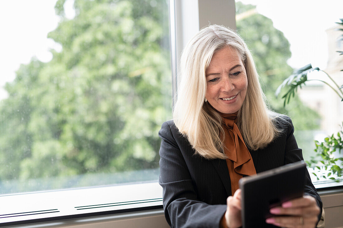 Lächelnde Geschäftsfrau mit digitalem Tablet