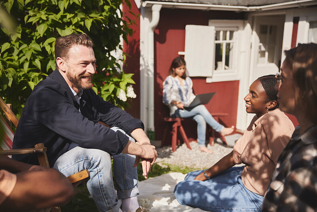 Freunde sitzen zusammen im Garten