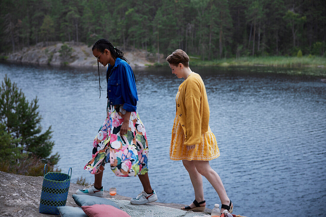 Female couple walking on cliff by river