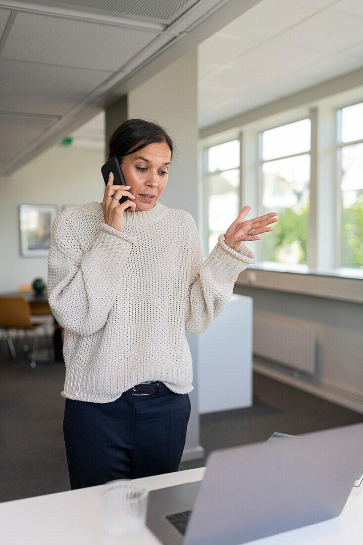 Frau telefoniert im Büro