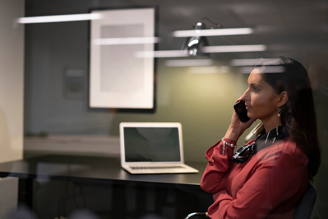 Businesswoman talking via phone in office