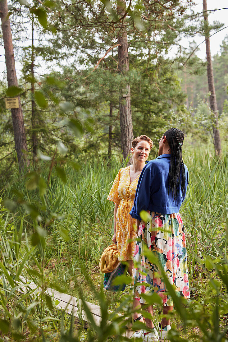 Female couple standing in forest