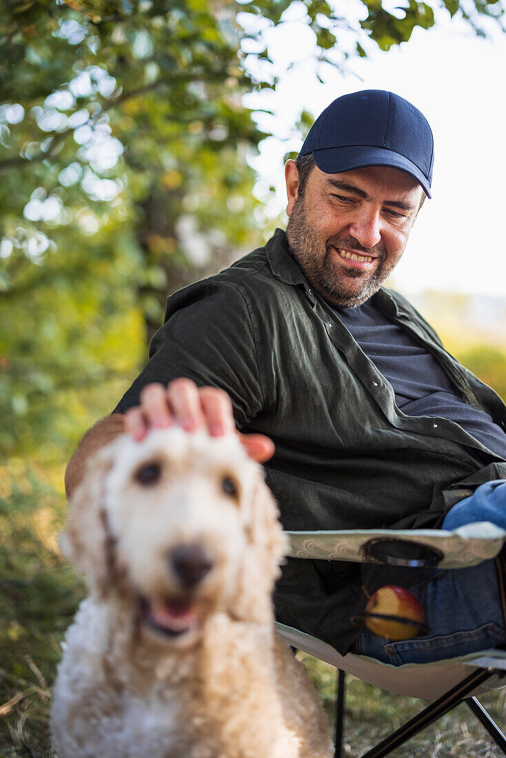 Mann sitzend mit Hund