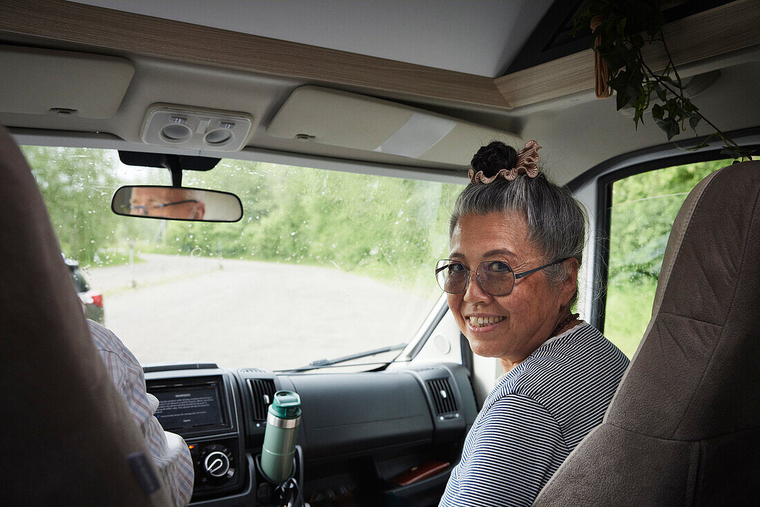 Portrait of smiling senior woman sitting in van