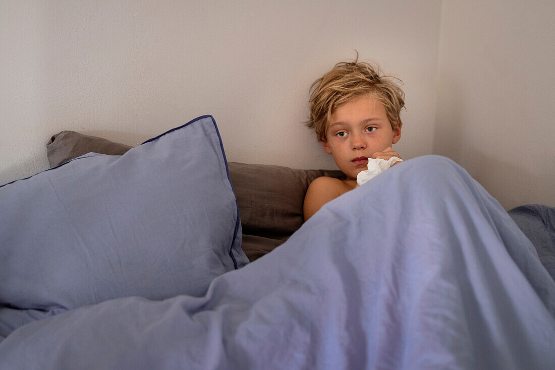 Sick boy lying in bed