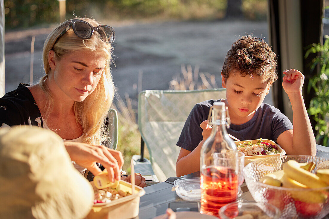 Mutter und Tochter beim Essen im Freien