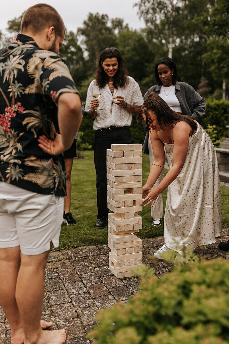 Freunde spielen Jenga im Garten