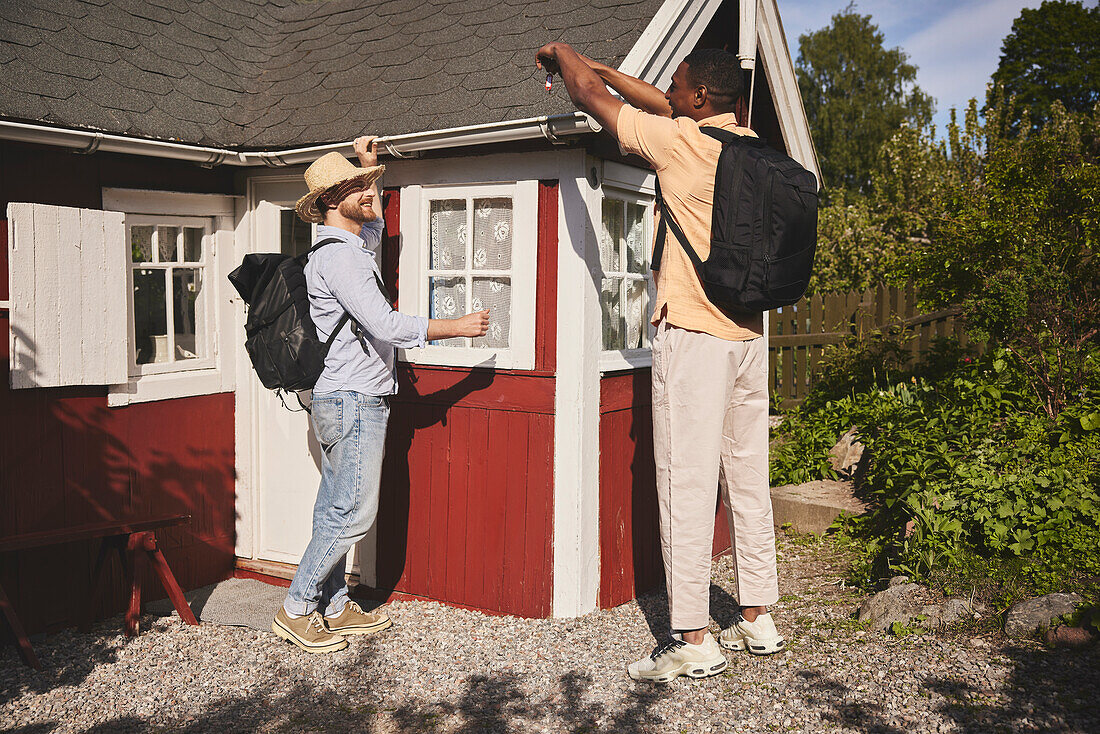 Young men standing in front of wooden house