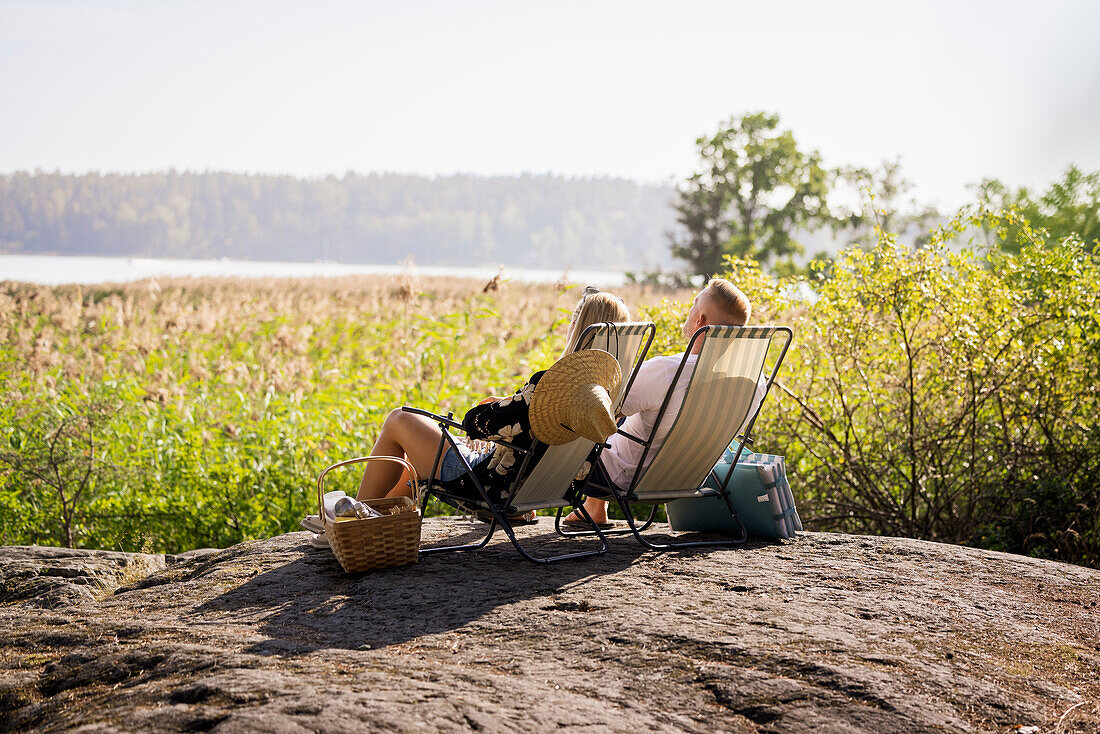 Couple sunbathing on lounge chairs