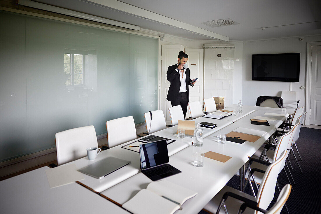 Businessman standing in empty boardroom