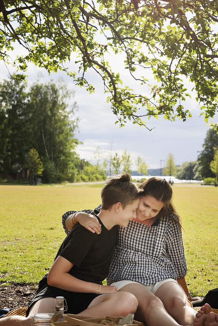 Mother with son sitting on picnic blanket