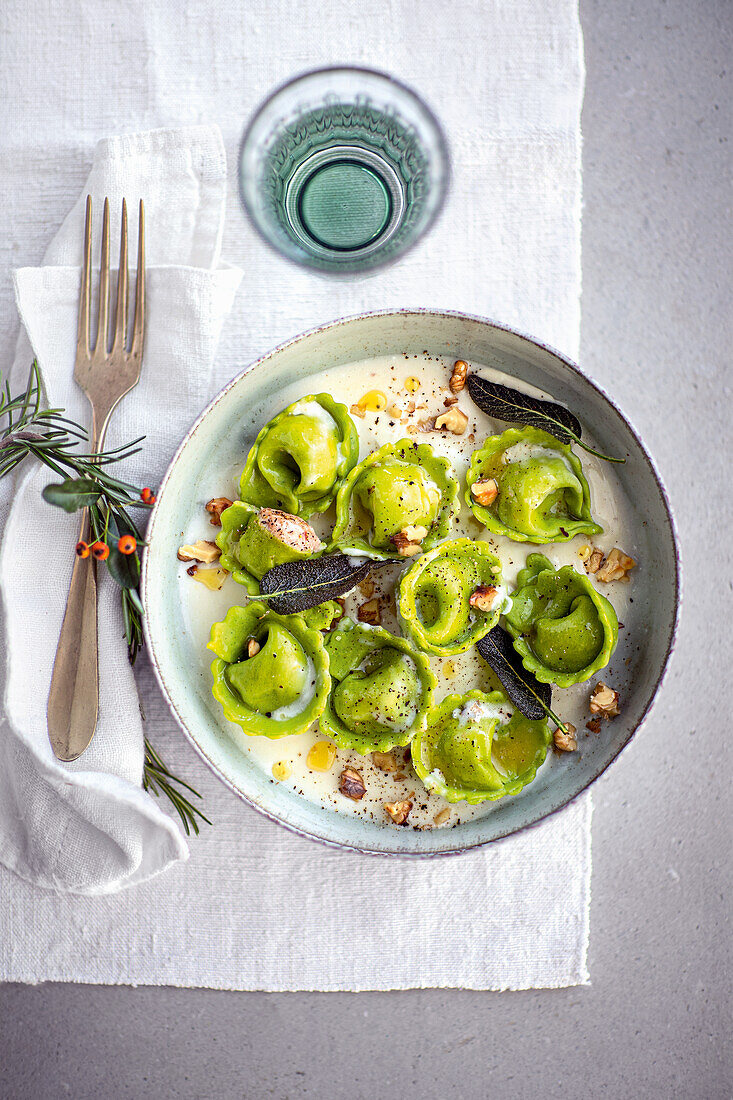 Grüne Brot-Tortelli auf Käsefondue-Sauce mit Nüssen