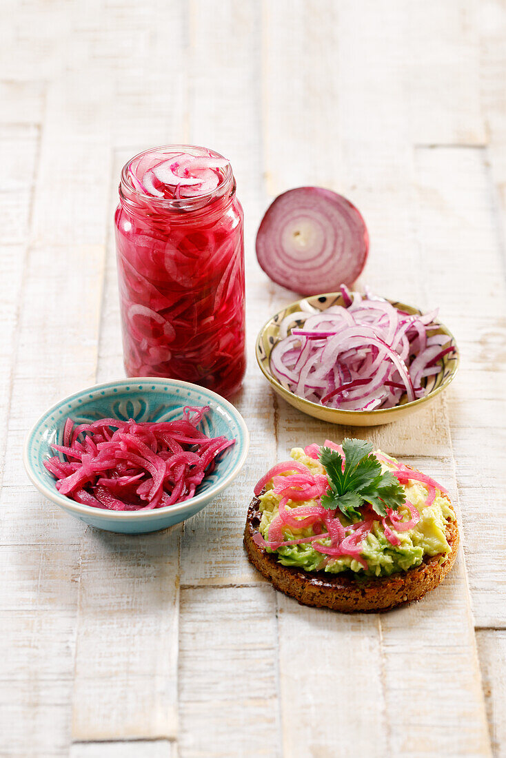 Bread topped with avocado cream and pickled red onions