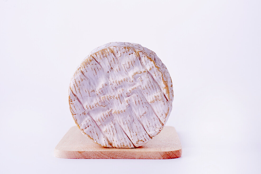 Camembert cheese on wooden board