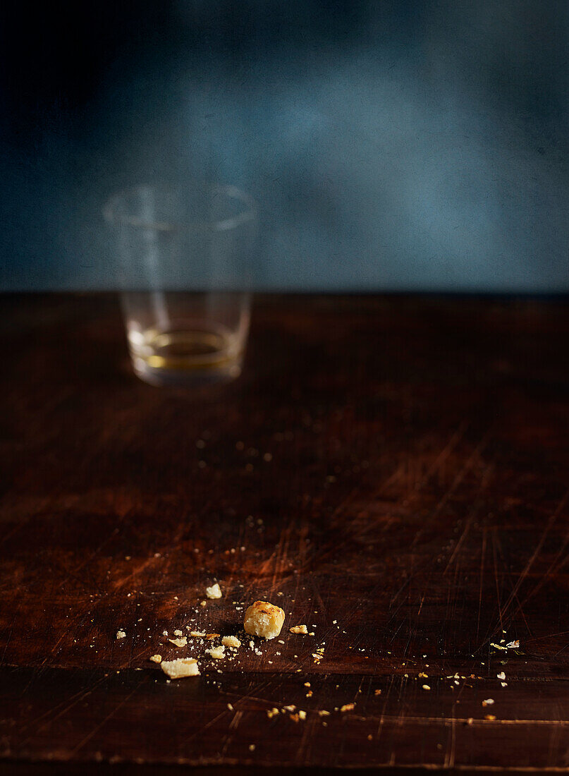 Crumbs and an empty glass on rustic wooden table