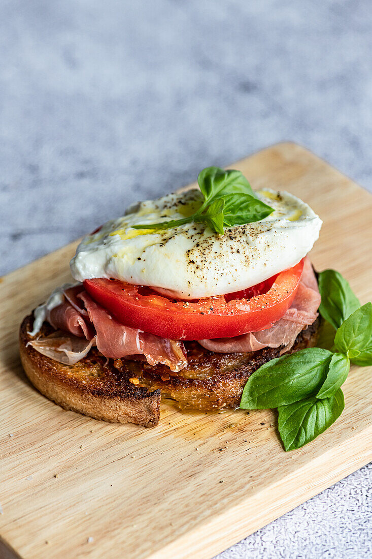 Open Toasted Sandwich with Serrano Ham, Beef Tomato, Burrata, Olive Oil and Fresh Basil