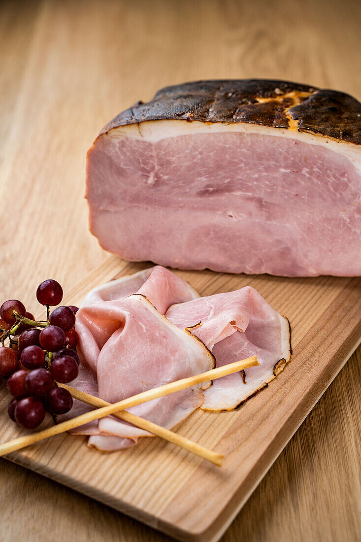 Ham partially sliced on a wooden board